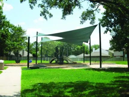 green H sail shade over playground